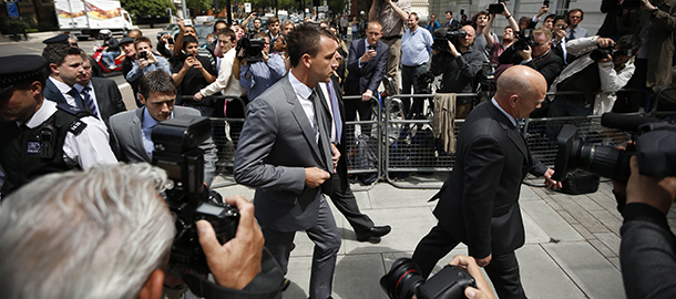 Former England soccer captain and Chelsea player John Terry, center, arrives at Westminster Magistrates Courts in London, Friday, July 13, 2012. The racism trial of Terry began Monday with prosecutors claiming the Chelsea captain acknowledges using offensive language as a "sarcastic exclamation" in response to taunts that he allegedly had an affair. The England defender is accused of racially abusing Queens Park Rangers defender Anton Ferdinand, who is black, during a Premier League match in October. (AP Photo/Matt Dunham)