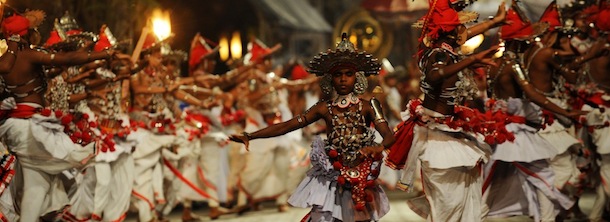 Sri Lankan Kandyan dancers perform in front of the historic Buddhist Temple of the Tooth, as they take part in a procession during the Esala Perahera festival in the ancient hill capital of Kandy, some 116 kms from Colombo on August 1, 2012. The festival features a nightly procession of Kandyan dancers, fire twirlers, traditional musicians, acrobatic fire performers and elephants and draws thousands of tourists and spectators from around the island. AFP PHOTO/Ishara S.KODIKARA (Photo credit should read Ishara S.KODIKARA/AFP/GettyImages)