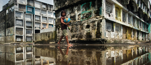 A boy who lives in a cemetery walks through the remains of floodwaters that receded from the Navotas cemetery in Navotas city on the outskirts of Manila on August 12, 2012. Emergency relief officials and doctors deployed to flood devastated communities in the Philippines on August 12 to prevent outbreaks of disease as the death toll jumped to 85. AFP PHOTO/ Nicolas ASFOURI (Photo credit should read NICOLAS ASFOURI/AFP/GettyImages)