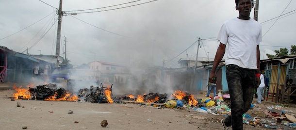 a supporters of the opposition's National Union (UN) party leader Andre Mba Obame walks in front of burning garbage during violent clashes with police in Libreville on August 15, 2012. Clashes broke out in Gabon's capital Libreville when police broke up an unauthorised protest in support of the country's main opposition leader, leaving at least 10 people injured. AFP PHOTO / XAVIER BOURGOIS (Photo credit should read XAVIER BOURGOIS/AFP/GettyImages)