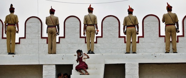 Members of police wait with their trumpets to perform as a school girl sits on steps during a gathering on the occasion of 65th anniversary of India's independence from British rule, in Bangalore, India, Wednesday, Aug. 15, 2012. (AP Photo/Aijaz Rahi)