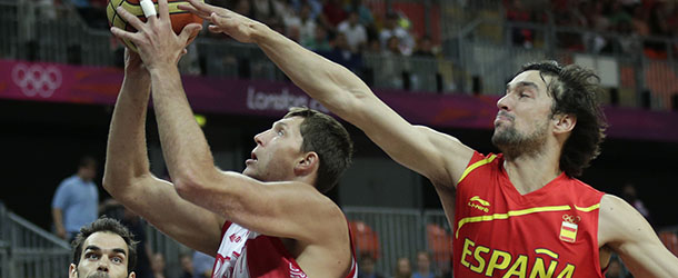 Spain's Pau Gasol, right, reaches for a block as Russia's Victor Khryapa drives to the basket during a men's basketball game at the 2012 Summer Olympics, Saturday, Aug. 4, 2012, in London. At left is Spain's Rudy Fernandez. (AP Photo/Charles Krupa)