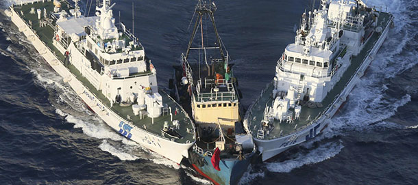A boat, center, is surrounded by Japan Cost Guard's patrol boats after some activists descended from the boat on Uotsuri Island, one of the islands of Senkaku in Japanese and Diaoyu in Chinese, in East China Sea Wednesday, Aug. 15, 2012. Regional tensions flared on the emotional anniversary of Japanâs World War II surrender as activists from China and South Korea used Wednesdayâs occasion to press rival territorial claims, prompting 14 arrests by Japanese authorities. The 14 people had traveled by boat from Hong Kong to the disputed islands controlled by Japan but also claimed by China and Taiwan. (AP Photo/Yomiuri Shimbun, Masataka Morita) JAPAN OUT, MANDATORY CREDIT
