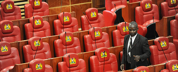 An employee of Kenya's parliament walks past it's newly refurbished seats on August 8, 2012. Kenya's president Mwai Kibaki opened parliament on August 7, 2012, newly refurbished at a cost of over $11 million and kitted out with 350 plush red leather seats for lawmakers each with a pricetag of $2,400. AFP PHOTO/SIMON MAINA (Photo credit should read SIMON MAINA/AFP/GettyImages)
