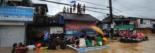 Rescuers use rubber boats to evacuate residents from their flooded homes in the village of Tumana, Marikina town, in suburban Manila on August 7, 2012, after torrential rains inundated most of the capital. Torrential rains brought the Philippines capital to a standstill on August 7 forcing at least 20,000 people to flee their homes as floodwaters covered half the sprawling city, authorities said. AFP PHOTO / TED ALJIBE (Photo credit should read TED ALJIBE/AFP/GettyImages)