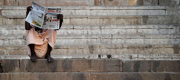This picture shows a man reading a newspaper by the Ganges river on April 26, 2012 in Varanasi. AFP PHOTO / GABRIEL BOUYS (Photo credit should read GABRIEL BOUYS/AFP/GettyImages)