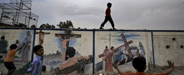 Pakistani Christian boys play next to a wall with biblical paintings, on Good Friday in a neighborhood in Islamabad, Pakistan, Friday, April 6, 2012. Christians around the world are marking the Easter holy week. (AP Photo/Muhammed Muheisen)

