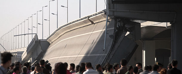 People gather after a section of the ramp of the Yangmingtan Bridge collapsed, in Harbin in northeast China's Heilongjiang province Friday, Aug. 24, 2012. Four trucks fell off the highway bridge when it collapsed in the morning, killing three people and injuring five others, according to local state media. The bridge was only opened to traffic in November. (AP Photo) CHINA OUT