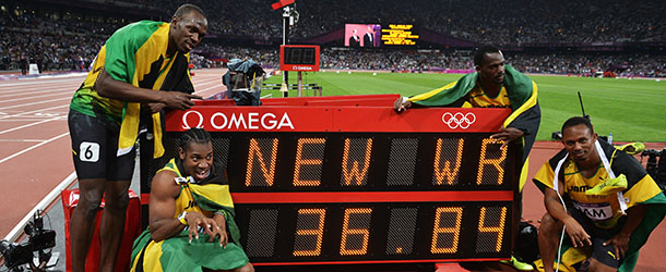 LONDON, ENGLAND - AUGUST 11: Usain Bolt, Yohan Blake, Michael Frater and Nesta Carter of Jamaica celebrate next to the clock after winning gold and setting a new world record of 36.84 during the Men's 4 x 100m Relay Final on Day 15 of the London 2012 Olympic Games at Olympic Stadium on August 11, 2012 in London, England. (Photo by Stu Forster/Getty Images)