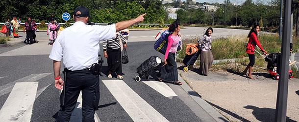 People from the Roma community walk along a road as they are expelled by police from their camp, on August 9, 2012 in the central French city of Villeurbanne, outside Lyon. AFP PHOTO/PHILIPPE DESMAZES (Photo credit should read PHILIPPE DESMAZES/AFP/GettyImages)