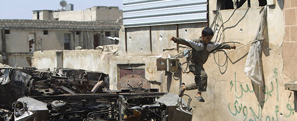 A Syrian boy jumps off a destroyed army armoured vehicle in the northern town of Atareb, 25 kms east of Syria's second largest city Aleppo, on July 31, 2012. While fighting raged in Syria's commercial capital Aleppo for a fourth straight day, clashes between the Syrian army and rebels also erupted in Damascus and other parts of the country, the Syrian Observatory for Human Rights said. AFP PHOTO/AHMAD GHARABLI (Photo credit should read AHMAD GHARABLI/AFP/GettyImages)