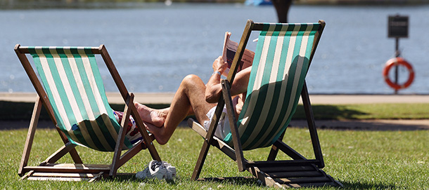 LONDON, UNITED KINGDOM - JULY 23: A man reads a newspaper in a deckchair next to the Serpentine lake in Hyde Park on July 23, 2012 in London, England. After weeks of wet weather parts of the UK are finally enjoying fine summer weather. (Photo by Oli Scarff/Getty Images)