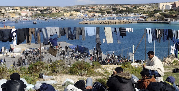 Migrants sit and take some rest on the tiny island of Lampedusa, Italy, Monday, March 21, 2011. Italy warned Monday that it was facing a refugee and humanitarian emergency, with some 15,000 Tunisians having arrived in recent weeks and fears that the start of U.S. and European airstrikes on Libya could unleash even more migrants. Italy has demanded Europe as a whole share the burden of coping with the immigration flows, saying it shouldn&#8217;t be expected to cope with alone. As it is, the number of Tunisians on the tiny island of Lampedusa, 4,800 as of Monday, was almost the size of the 5,000-strong population itself. Lampedusa&#8217;s residents are getting increasingly angry over the government&#8217;s failure to help ease their burden. They have refused plans to set up a tent camp on the island, saying the migrants should be taken elsewhere. (AP Photo/Giuseppe Giglia)

