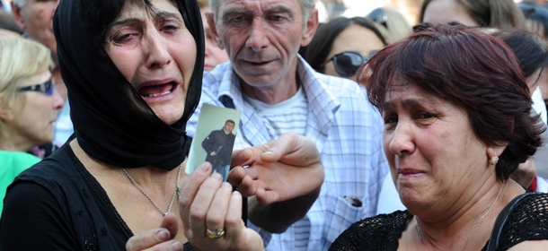 Women cry as they hold the picture of a relative during a protest rally against torture in prisons as demonstrators block one of the capital&#8217;s main streets in Tbilisi on September 19, 2012. Georgia&#8217;s prisons minister resigned today over videos showing the alleged beating and raping of convicts, causing outrage ahead of bitterly-contested elections in the ex-Soviet state. AFP PHOTO / VANO SHLAMOV (Photo credit should read VANO SHLAMOV/AFP/GettyImages)
