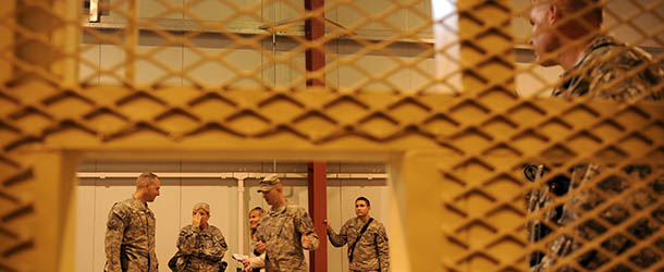 US soldiers are seen near a common cell during a media tour of Bagram prison, north of Kabul, on November 15, 2009. A human rights group is calling on the United States to develop a new detention policy with Kabul for a US military prison in Afghanistan dubbed the "Afghan Guantanamo." The detention center located at Bagram Air Base north of Kabul holds some 600 detainees captured by US forces in Afghanistan. AFP PHOTO/Massoud HOSSAINI (Photo credit should read MASSOUD HOSSAINI/AFP/Getty Images)