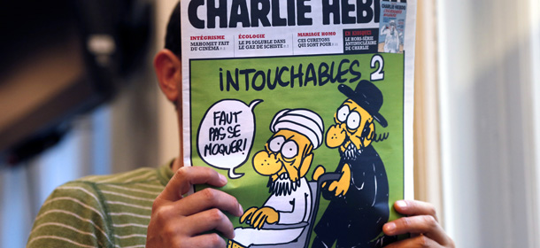 A man reads on September 19, 2012 in Paris, the back cover of French satirical weekly Charlie Hebdo which features on the front cover of its September 19 issue a satirical drawing titled &#8220;Intouchables 2&#8243;. The title refers to &#8220;Intouchables&#8221;, a 2012 French movie, the most seen French movie abroad, which is selected to represent France for the Oscars nominees, according to one of his directors, Eric Toledano. Inside pages contain several cartoons caricaturing the Prophet Mohammed. The magazine&#8217;s decision to publish the cartoons came against a background of unrest across the Islamic world over a crude US-made film that mocks Mohammed and portrays Muslims as gratuitously violent. AFP PHOTO THOMAS COEX (Photo credit should read THOMAS COEX/AFP/GettyImages)
