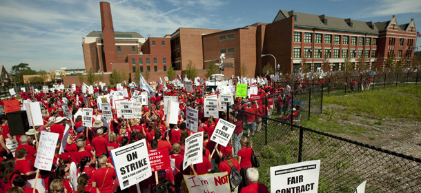 A large group of public school teachers marches past John Marshall Metropolitan High School on Wednesday, Sept. 12, 2012 in West Chicago. Teachers walked off the job Monday for the first time in 25 years over issues that include pay raises, classroom conditions, job security and teacher evaluations. (AP Photo/Sitthixay Ditthavong)