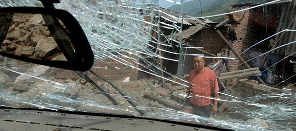 A villager stands outside his damaged home on September 9, 2012 after a series of earthquakes hit Yiliang County, Yunnan Province on September 7. Rescuers searching for survivors from twin earthquakes that struck southwestern China battled blocked roads and downed communications as the death toll rose to 80. Some 820 people were injured and 201,000 displaced after two 5.6-magnitude quakes struck the resource rich but impoverished region on September 7. AFP PHOTO/Mark RALSTON (Photo credit should read MARK RALSTON/AFP/GettyImages)