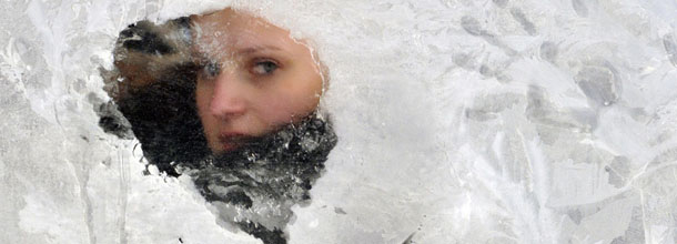 A girl looks out from a frozen bus window on January 25, 2010 in the western Ukrainian city of Lviv, where temperatures reached minus 20 degrees Celcius. AFP PHOTO/ YURIY DYACHYSHYN (Photo credit should read YURIY DYACHYSHYN/AFP/Getty Images)