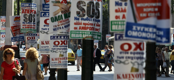 Pedestrians walk among banners reading: &#8221;General Strike,&#8221; &#8221;SOS,&#8221; &#8221;No,&#8221; &#8221;All together&#8221; announcing Wednesday&#8217;s general strike in Athens, Tuesday, Sept. 25, 2012. Unions have called a nationwide general strike Wednesday to protest new austerity measures being hammered out between the government and Greece&#8217;s international creditors to ensure the country continues receiving emergency loans that have kept it afloat since 2010. (AP Photo/Thanassis Stavrakis)
