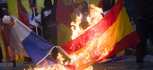 Left-wing indenpendentist demonstrators burn a Spanish and French flag on top of a stage, as part of a performance following a protest rally in Barcelona, Spain, Tuesday, Sept. 11, 2012. Thousands of people demonstrated in Barcelona on Tuesday demanding independence for Catalonia, on the Catalan region's 'National Day". (AP Photo/Jose Colon)