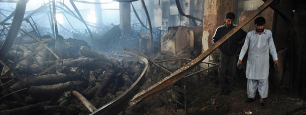 Pakistan people gather in a garment factory following a fire in which at least 289 people died in Karachi on September 13, 2012, on the third day of the fire incident. Police in Karachi have registered a murder case against the owners of a garment factory where a fire killed at least 289 people in the country's worst ever industrial disaster, officers said. AFP PHOTO/Rizwan TABASSUM (Photo credit should read RIZWAN TABASSUM/AFP/GettyImages)