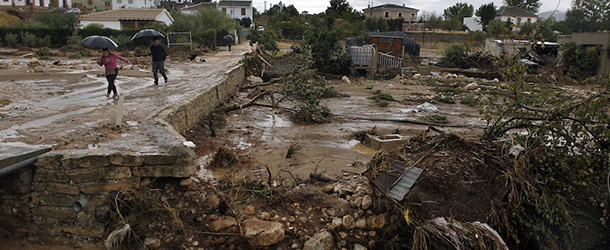 Residents walk on a muddy street after heavy rain caused flash floods in the town of Villanueva del Rosario, Malaga, southern Spain, Friday, Sept. 28, 2012. Homes were destroyed and at least one woman was killed. Rescue workers are searching to determine if there are more victims.(AP Photo/Sergio Torres)

