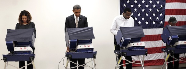 President Barack Obama, second from the left, casts his vote, during early voting, in the 2012 election at the Martin Luther King Community Center, Thursday, Oct. 25, 2012, in Chicago. (AP Photo/Pablo Martinez Monsivais)
