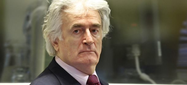 Former Bosnian Serb leader Radovan Karadzic appears in the courtroom of the ICTY War Crimes tribunal in the Hague on November 3, 2009. Wartime Bosnian Serb leader Radovan Karadzic made his first court appearance Tuesday since the start of his genocide trial more than a week ago. Wearing a black suit, pink shirt and red tie, Karadzic took his place in the accused dock of the International Criminal Tribunal for the former Yugoslavia, for a procedural hearing that will consider options for continuing the trial in the face of his defiance. AFP PHOTO &#8211; POOL / MICHAEL KOOREN (Photo credit should read MICHAEL KOOREN/AFP/Getty Images)
