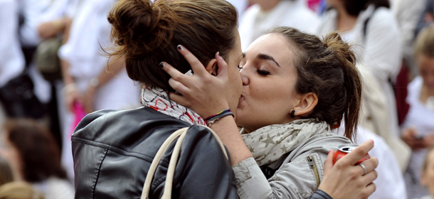 Two women kiss in front of people taking part in a demonstration called by the &#8220;Alliance VITA&#8221; association against gay marriage and adoption by same-sex couples on October 23, 2012 in Marseille, southeastern France. France on October 10 named October 31 as the date when a draft law authorising gay marriage will be approved by government ministers, amid mounting opposition to the proposed legislation. AFP PHOTO/GERARD JULIEN (Photo credit should read GERARD JULIEN/AFP/Getty Images)
