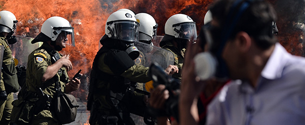 A fireboomb explodes near riot police during clashes with demonstrators during a 24-hour strike in Athens on October 18, 2012. Greek riot police fired tear gas to disperse protesters at an anti-austerity rally in Athens held during a national general strike as EU leaders were to tackle the eurozone crisis at a summit. The protesters had broken through a police line outside luxury hotels on central Syntagma Square and scattered groups of youths later attacked police with stones and firebombs, an AFP reporter said. AFP PHOTO / ARIS MESSINIS (Photo credit should read ARIS MESSINIS/AFP/Getty Images)
