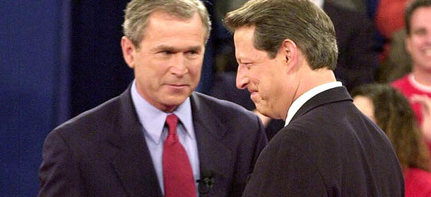 ST. LOUIS, UNITED STATES: Republican presidential nominee George W. Bush (C) looks at Democratic presidential nominee Al Gore after they shook hands before their third debate at Washington University in St. Louis, MO, 17 October, 2000. At left is moderator Jim Lehrer. AFP PHOTO (Photo credit should read AFP/AFP/Getty Images)
