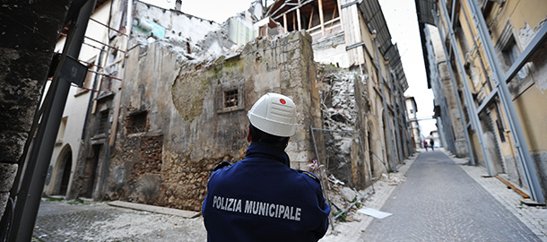 Apoliceman stands on April 2, 2012 near the &#8216;red zone&#8217; closed to public, in the historic area of L&#8217;Aquila devastated three years ago by an earthquake. Out of the 120,000 or so people affected by the 6.3 magnitude quake which hit the L&#8217;Aquila area on April 6, 2009, over 21,000 still live in new builds, temporary houses, hotels or army barracks while they wait for their homes to be repaired, or demolished and rebuilt. AFP PHOTO / ANDREAS SOLARO (Photo credit should read ANDREAS SOLARO/AFP/Getty Images)
