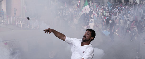 A Lebanese protester throws a tear gas canister back at security forces during clashes after the funeral of Brig. Gen. Wissam al-Hassan who was assassinated on Friday by a car bomb in Beirut, Lebanon, Sunday Oct. 21, 2012. (AP Photo/Hussein Malla)
