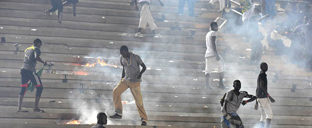 Fans set fire to stands on October 13, 2012 at LÃopold SÃdar Senghor stadium in Dakar during Ivory Coast&#8217;s African Cup of Nations qualifier against Senegal. The match was abandoned after home fans went on a violent rampage as their team slipped towards a humiliating defeat. Fires were set in the stands while stones, chairs and bottles were thrown at the players, an AFP journalist witnessed, after Ivory Coast went 2-0 ahead, 15 minutes from the end of the second leg of the tie. AFP PHOTO/SEYLLOU (Photo credit should read SEYLLOU/AFP/GettyImages)
