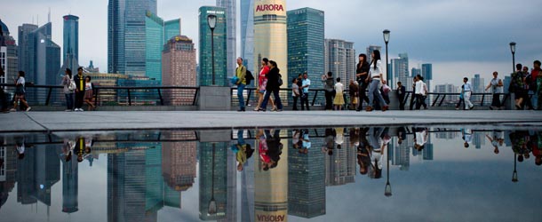 Pedestrians walk past the skyline of the city&#8217;s financial district in Shanghai on October 8, 2010. China is expected to overtake Japan as the second wealthiest country in the world by 2015 on the back of rapid economic growth and strong domestic consumption, a report said on October 8. AFP PHOTO/Philippe Lopez (Photo credit should read PHILIPPE LOPEZ/AFP/Getty Images)

