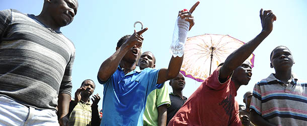 Striking mine workers protest outside the Anglo American Mine on October 5, 2012 in Rustenburg. South African police on October 5 recovered the body of a miner killed in clashes with striking workers at the platinum mine, as President Jacob Zuma appealed for an end to months of often violent industrial disputes. Miners said the man was killed late on October 4 when police used tear gas and rubber bullets to disperse a group of illegal strikers from the mine. Some 28,000 workers have been on a strike at Anglo American Platinum (Amplats), the world&#8217;s top platinum producer, since September 12, demanding higher wages. AFP PHOTO / STEPHANE DE SAKUTIN (Photo credit should read STEPHANE DE SAKUTIN/AFP/GettyImages)
