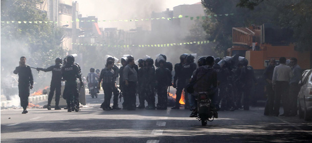 Iranian riot police stand next to a garbage container which is set on fire by protesters in central Tehran, near the main bazaar, on October 3, 2012, in the first sign of public unrest over Iran&#8217;s plunging currency. The rial, lost more than half of its value since last week as the plunge has greatly increased inflation in Iran, which is widely seen as far higher than the official 23.5 percent given by the central bank. AFP PHOTO/STR (Photo credit should read -/AFP/GettyImages)
