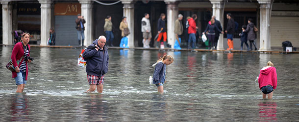 People walk on a flooded St Mark&#8217;s square during a &#8220;acqua alta&#8221; on October 27, 2012 in Venice. The &#8220;acqua alta&#8221;, a convergence of high tides and a strong sirocco, reached 127 centimeters in the morning. AFP PHOTO / ANDREA PATTARO (Photo credit should read ANDREA PATTARO,ANDREA PATTARO/AFP/Getty Images)
