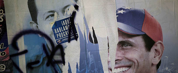Election campaign posters of presidential candidates, President Hugo Chavez, left, and Henrique Capriles, of the opposition, cover a wall at a polling station during the presidential election in the Catia neighborhood of Caracas, Venezuela, Sunday, Oct. 7, 2012. (AP Photo/Rodrigo Abd)
