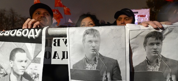 Russian opposition activists hold posters bearing portraits of jailed opposition activists Vladimir Akimenkov and Leonid Razvozzhayev during a rally in central Moscow on October 30, 2012. Several hundred people took part in a rally to show support to jailed opposition activists. Russia has over the past few months targeted many protest activists in various probes, with 13 people behind bars and awaiting trial on charges of alleged disorder at a massive rally on May 6, one day before Vladimir Putin was inaugurated for his third Kremlin term. AFP PHOTO/KIRILL KUDRYAVTSEV (Photo credit should read KIRILL KUDRYAVTSEV/AFP/Getty Images)
