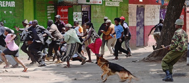 A Kenyan Police officer with a guard dog tries to control a crowd in the somali district of Eastleigh in Nairobi on November 19, 2012 a day after a bomb exploded in a minibus, killing seven. Police used tear gas and fired into the air to contain the violence which erupted after the bomb exploded. Kenyan residents in Eastleigh turned on Somalis and attacked their shops and stalls, accusing them of being responsible for the bomb. AFP PHOTO/CARL DE SOUZA (Photo credit should read CARL DE SOUZA/AFP/Getty Images)
