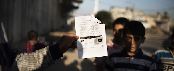 A Palestinian man holds up a leaflet dropped by Israeli air force in the Tufah neighbourhood of Gaza City on November 20, 2012, urging residents of certain districts of the city to evacuate their homes &#8220;immediately&#8221; amid fears the military was poised to launch a ground operation. AFP PHOTO/MARCO LONGARI (Photo credit should read MARCO LONGARI/AFP/Getty Images)
