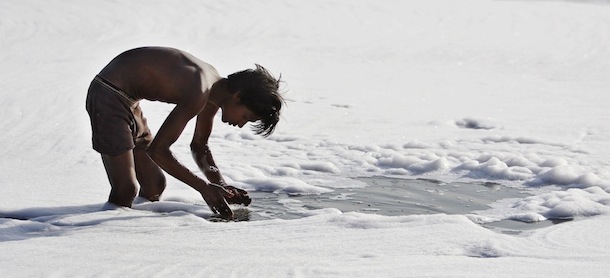 An Indian boy looks for reusable material in the polluted waters of the Yamuna River in New Delhi, India, Sunday, April 22, 2012. April 22 is observed as Earth Day every year as a tool to raise ecological awareness. (AP Photo/Tsering Topgyal)
