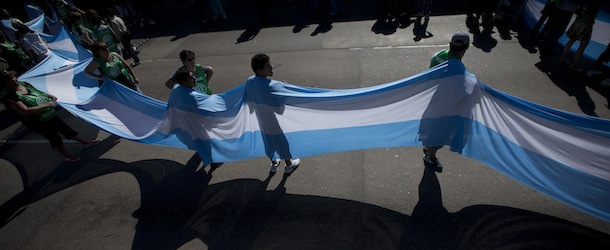 Workers carry an Argentine flag as they block a bridge leading to Buenos Aires during a general strike in Buenos Aires, Argentina, Tuesday, Nov. 20, 2012. Argentina&#8217;s biggest unions are holding their first national strike against President Cristina Fernandez to demand a higher minimum wage and protest against rising inflation, among other demands.(AP Photo/Victor R. Caivano)
