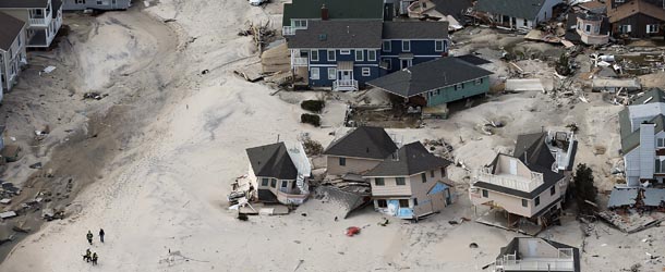 SEASIDE HEIGHTS, NJ &#8211; OCTOBER 31: Rescue workers (LOWER L) walk past homes wrecked by Superstorm Sandy on October 31, 2012 in Seaside Heights, New Jersey. At least 50 people were reportedly killed in the U.S. by Sandy with New Jersey suffering massive damage and power outages. (Photo by Mario Tama/Getty Images)
