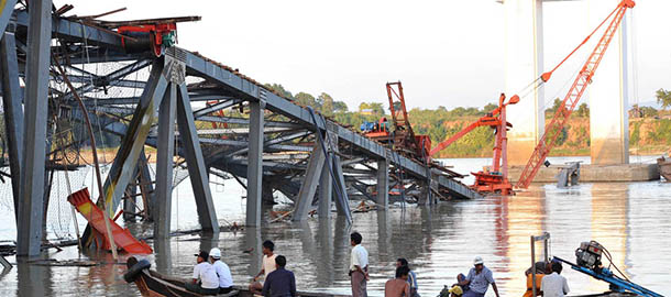 People on a boat work near a damaged bridge in Kyauk Myaung township, east of Shwebo, following a powerful earthquake that hit Myanmar killing at least 13 people, injured dozens and sparking panic in the major central city of Mandalay on November 11, 2012. The shallow 6.8-magnitude quake struck in a rural area 116 kilometres (72 miles) north of Mandalay followed by a series of aftershocks, the US Geological Survey (USGS) said. AFP PHOTO / Soe Than WIN (Photo credit should read Soe Than WIN/AFP/Getty Images)
