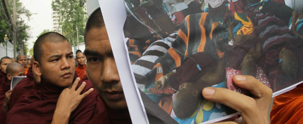 Buddhist monks from Myanmar hold up a photo of their comrades in their homeland who suffered burn injuries when police ousted them Thursday from a campsite at a copper mine near Monywa in northwestern Myanmar, during a protest in front of Myanmar Embassy in Bangkok, Thailand, Friday, Nov. 30, 2012. Those injured monks had joined villagers there in the protest to stop the mine&#8217;s operations because they claim it causes environmental and social problems. (AP Photo/Sakchai Lalit)

