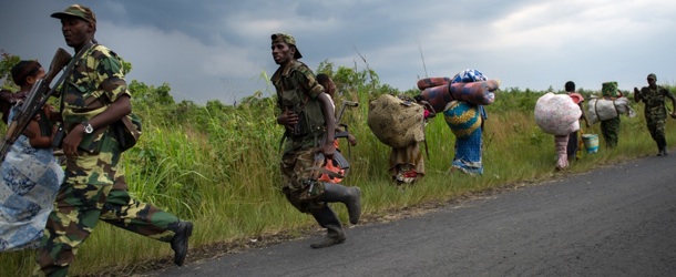 M23 rebels run towards the town of Sake, 26km west of Goma, as thousands of residents flee fresh fighting in the eastern Democratic Republic of the Congo town on November 22, 2012. Fighting broke out this afternoon causing people to flee the town and head east, towards Goma, to the camps for the internally displaced in the village of Mugunga. AFP PHOTO/PHIL MOORE (Photo credit should read PHIL MOORE/AFP/Getty Images)
