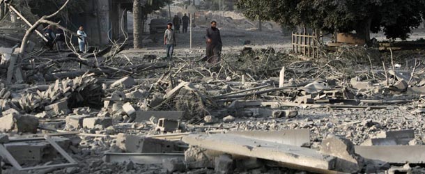 Palestinian men walk amidst debris at the destroyed compound of the internal security ministry in Gaza City after it was targeted by an Israeli air strike overnight on November 21, 2012. Fighting raged on both sides of Gaza&#8217;s borders Wednesday despite intensified efforts across the region to thrash out a truce to end a week of violence that has cost 136 Palestinian and five Israeli lives. AFP PHOTO/MAHMUD HAMS (Photo credit should read MAHMUD HAMS/AFP/Getty Images)
